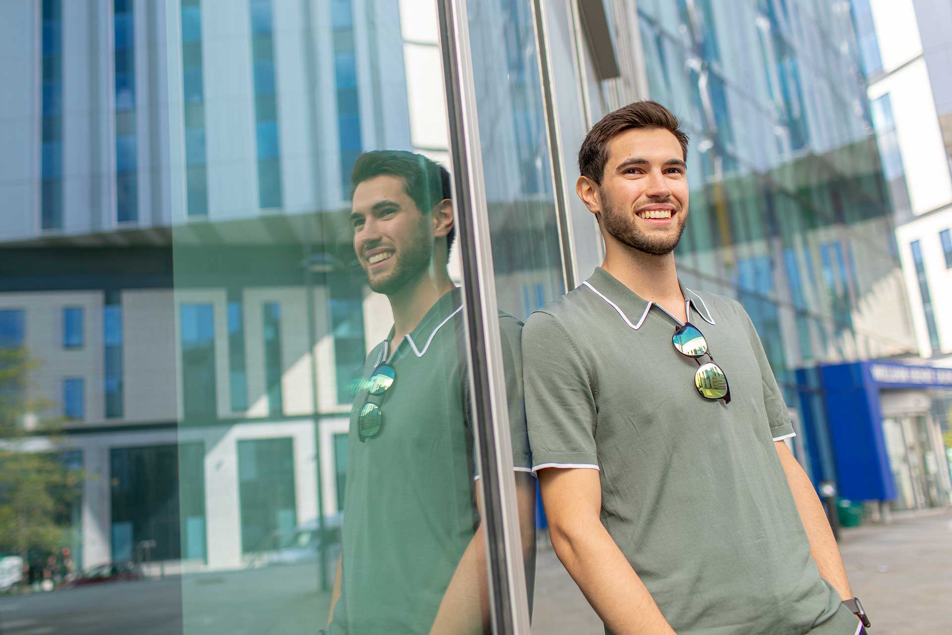 A student stands outside a building on campus.