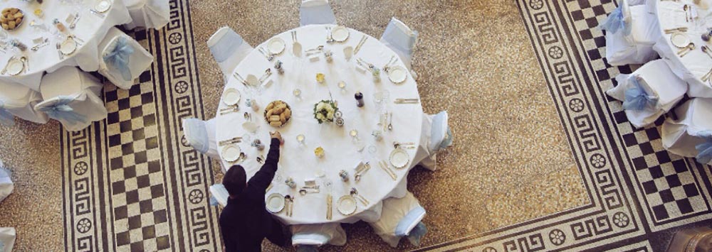 A member of staff setting up a table for a wedding in the Grand Hall, Victoria Gallery and Museum.