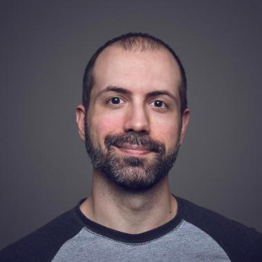 man with beard wearing grey and navy t shirt