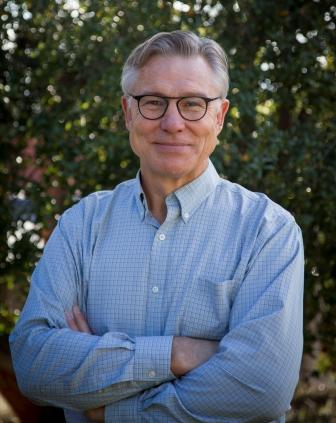 man in blue shirt with folded arms