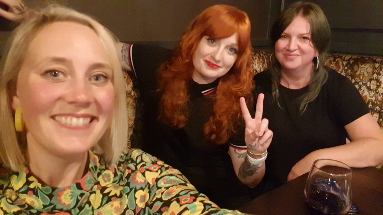 three women facing the camera smiling