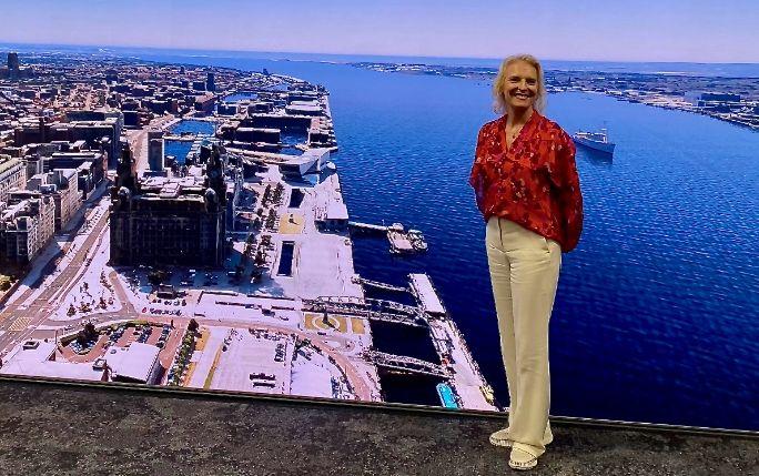 woman standing in front of a colourful waterfront image