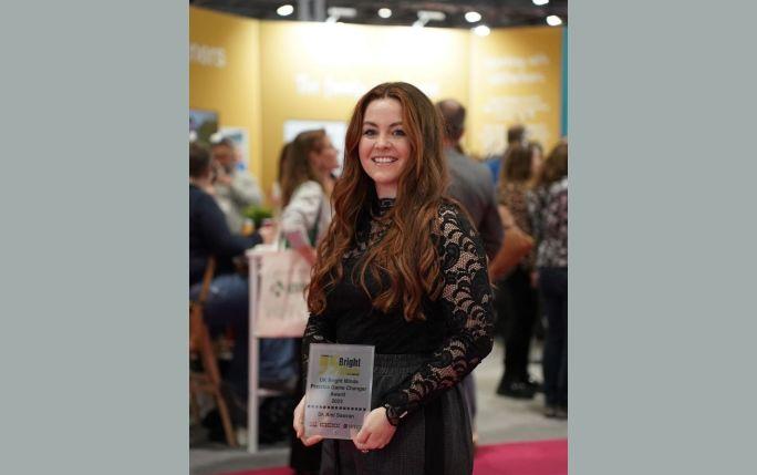 Ami smiling, holding her award