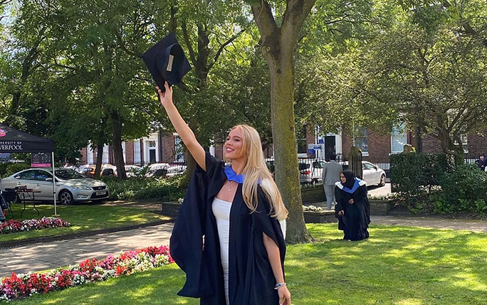 Graduate holding her cap out on graduation day