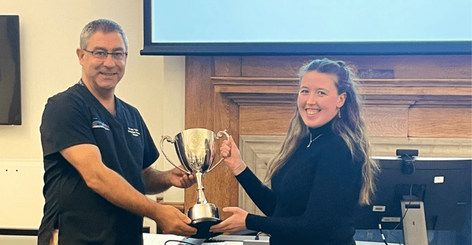 John handing a trophy to a student