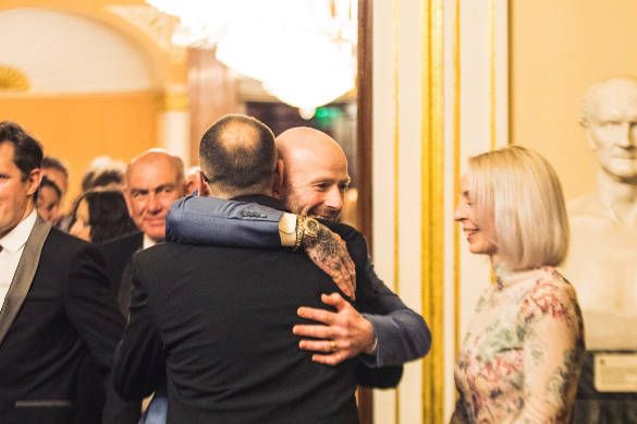 Two vet ball attendees hugging in greeting in the reception room of the Liverpool Town Hall