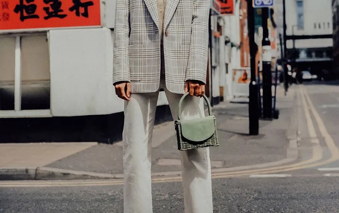 Model wears mint green Wicker Wings bag