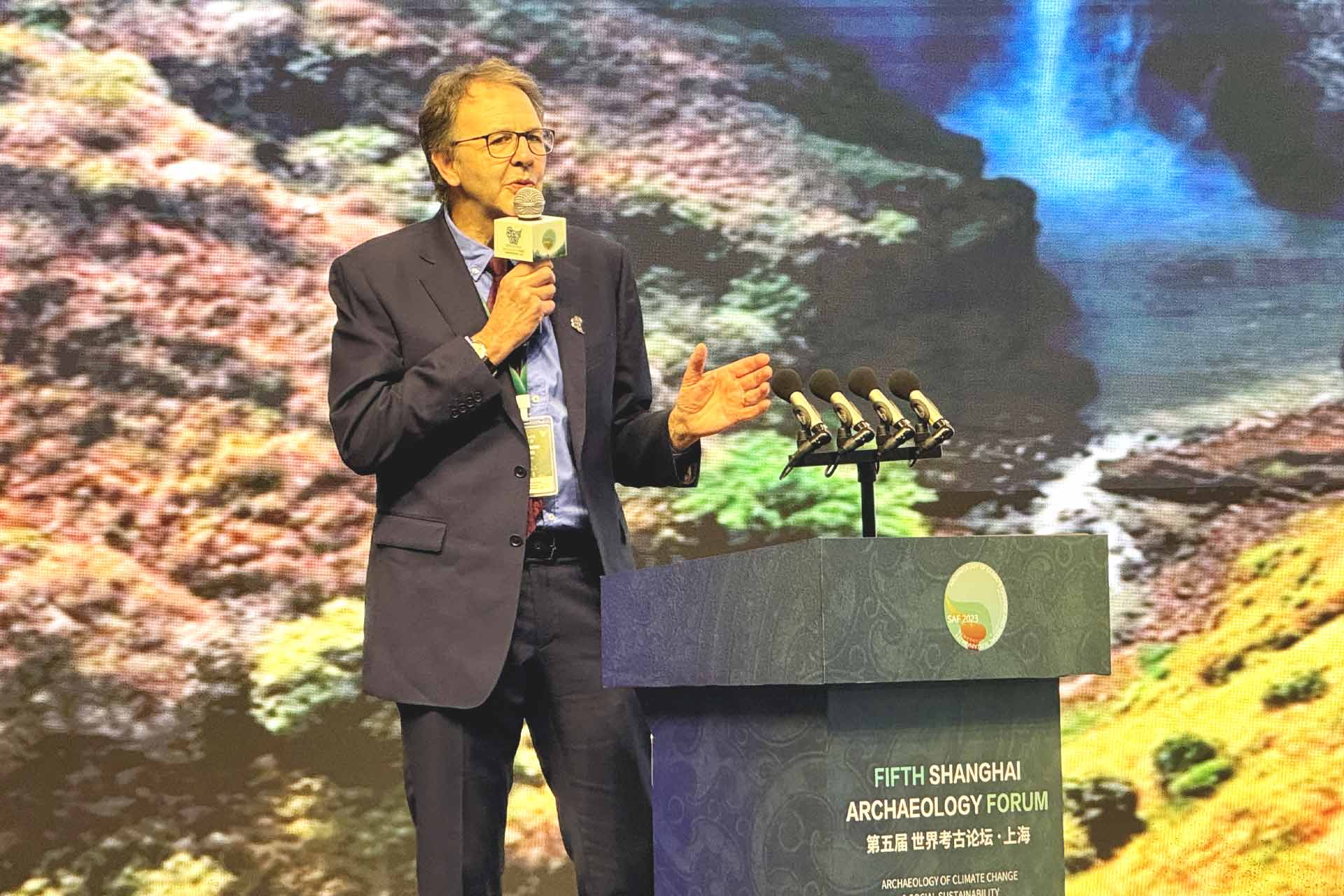 Larry presenting in front of a backdrop of Kalambo falls receiving award in China