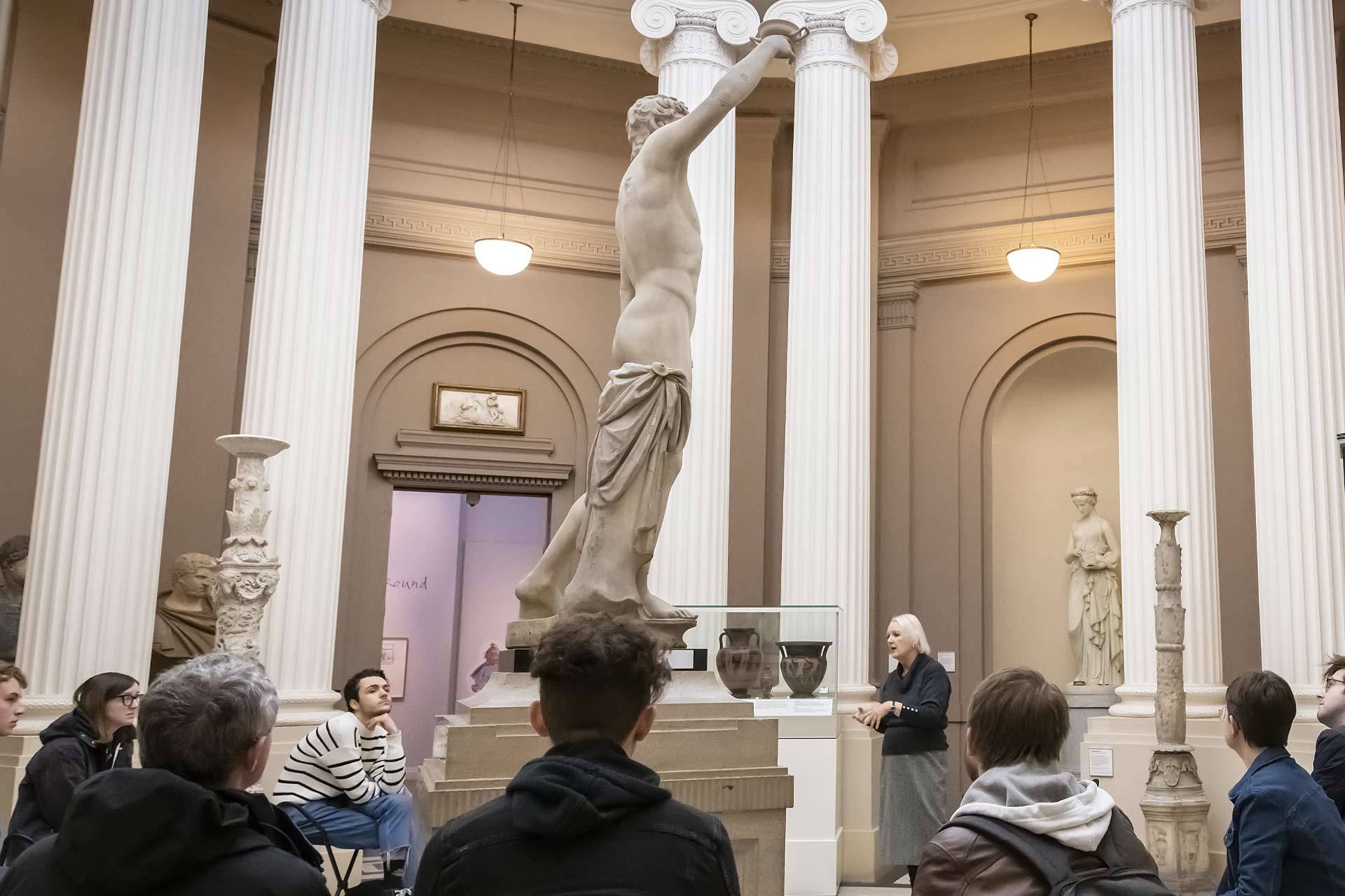 Students gathered round an ancient statue