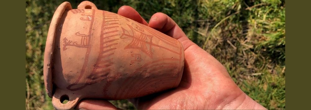 a small clay pot held in an open palm