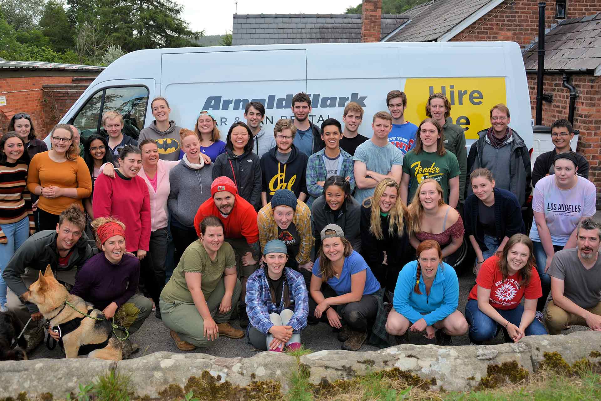 A large group photo of many students all gathered facing the camera outside.