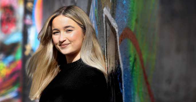 Girl in front of graffiti looking at the camera