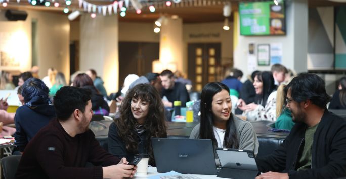 students sitting together on a busy hall