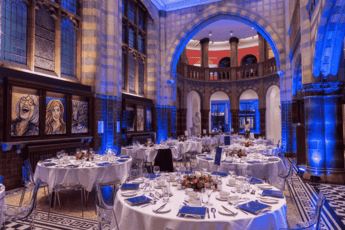 A photo of the VGM with lots of dressed dinner tables and blue backdrop lighting