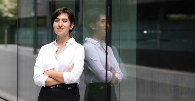 A student standing by a window