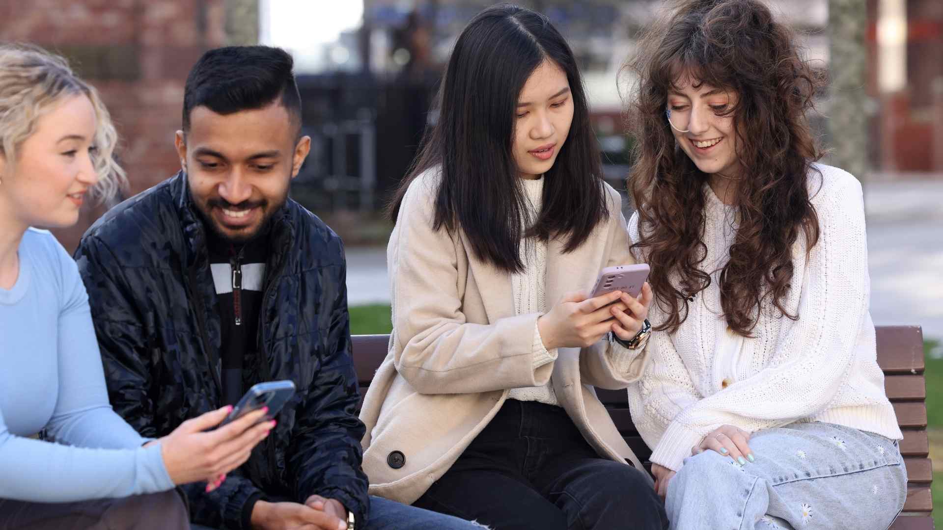 Graduates looking at their phones