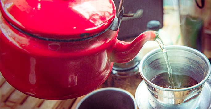 Teapot pouring tea in cup