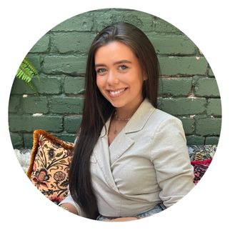 A student with long brown hair smiling.