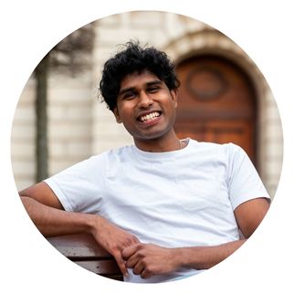 A smiling student sitting on a bench.