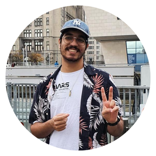 A student smiling and wearing a baseball cap.