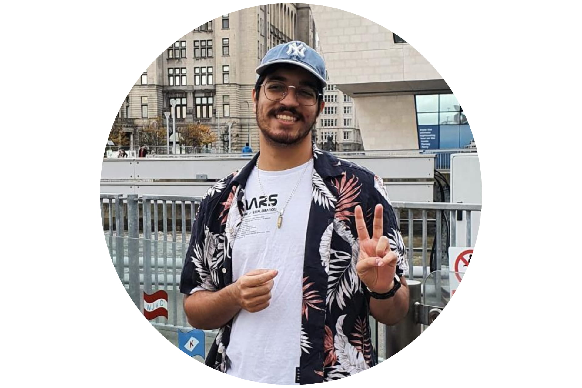 A student wearing a baseball cap and smiling.