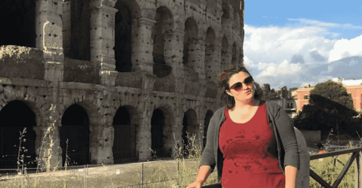 A student stands outside the colosseum in Rome