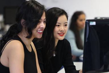 Two students looking at a monitor