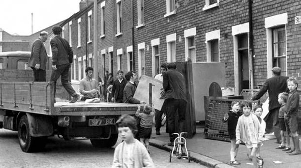 Black and white photo of people unpacking belongings