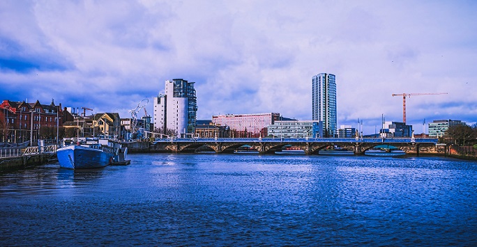 cityscape of Belfast, with tower blocks and the river in the foreground