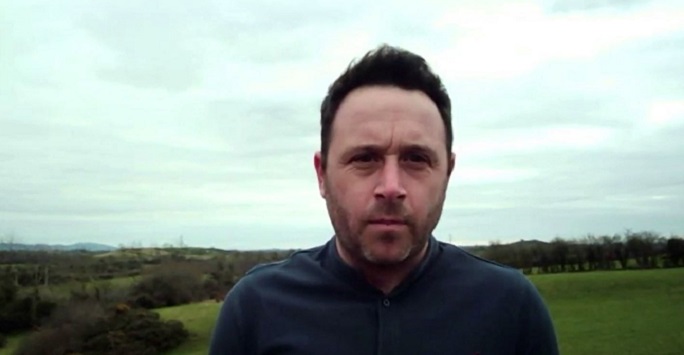 cllr pete byrne standing in a green field wearing dark clothes