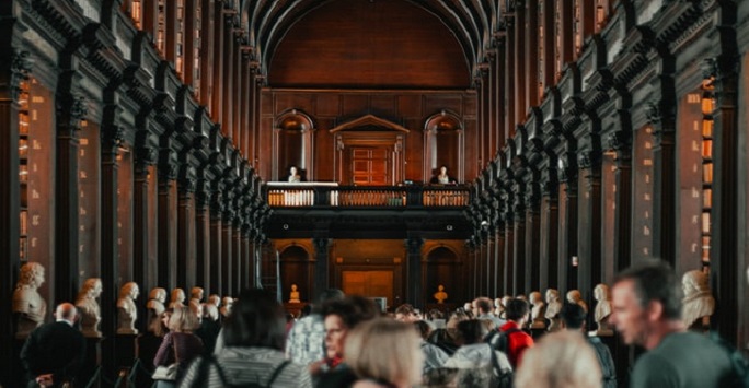 large gathering of people in a grand vaulted ceiling hall