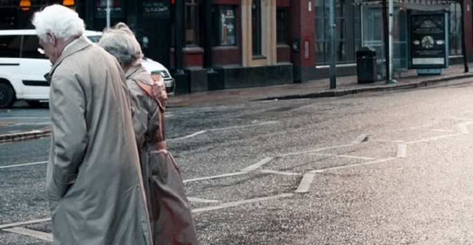 elderly couple crossing the road