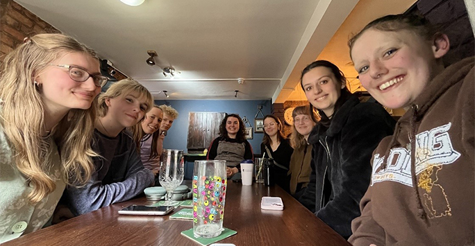 Group of students sat around a table in a pub for Stammtisch