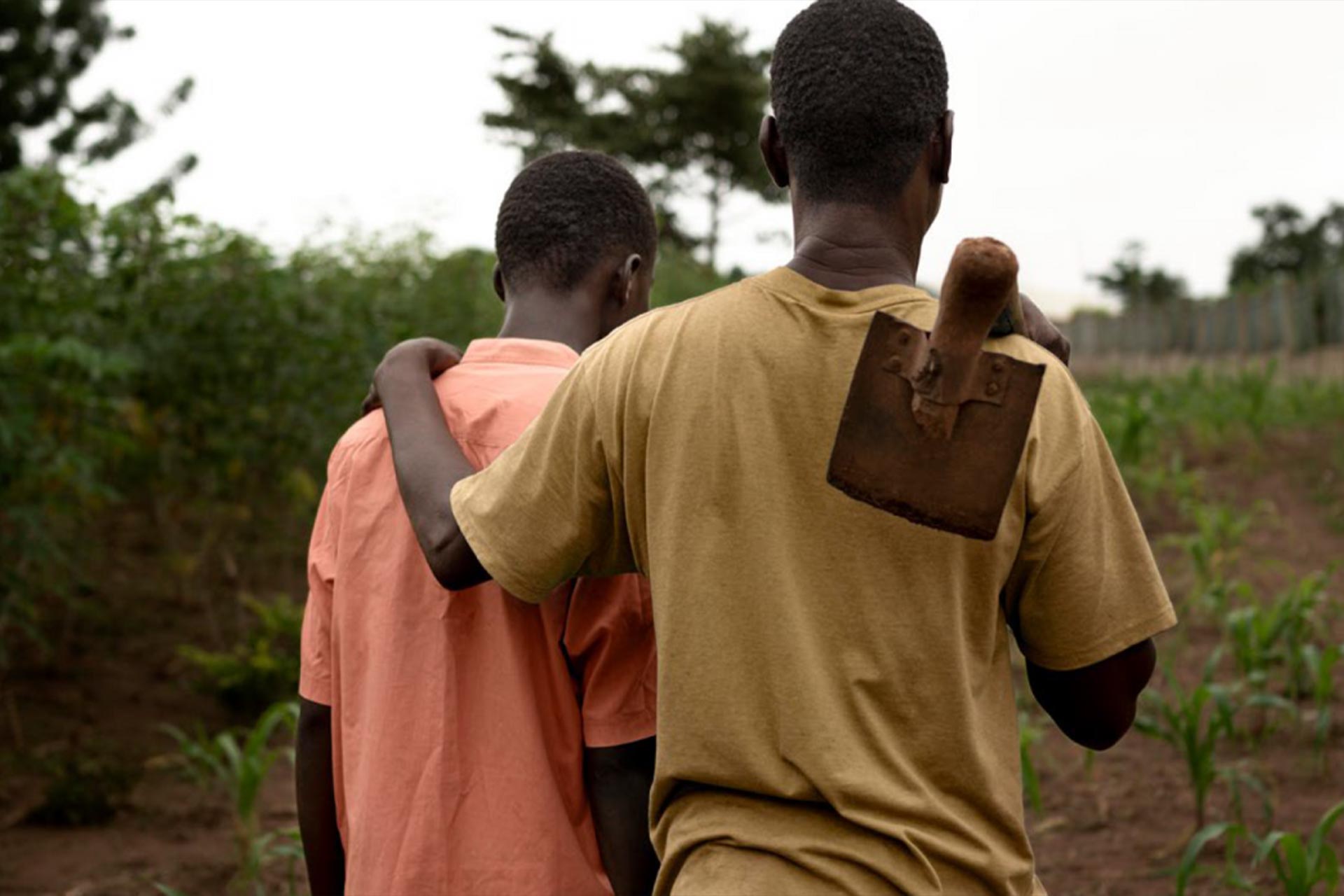 Two boys walking together holding each others backs