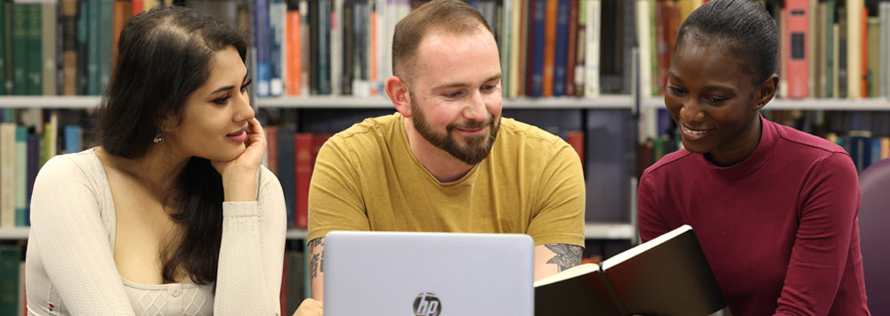 Three Students At a Laptop