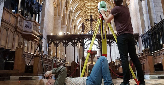 Medieval church interior with researchers