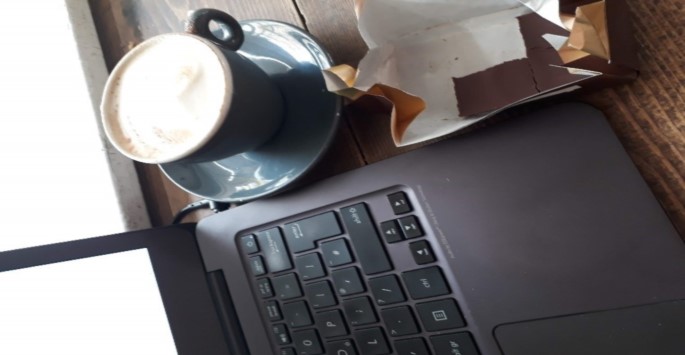 Workspace set up for writing retreat with coffee, chocolate, and laptop.