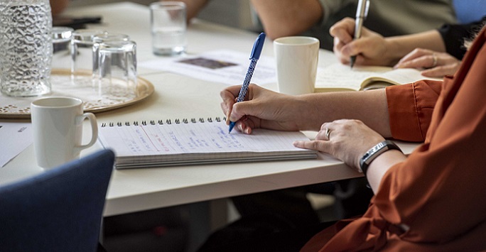 People at a table together taking notes