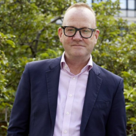 A headshot of a man wearing glasses