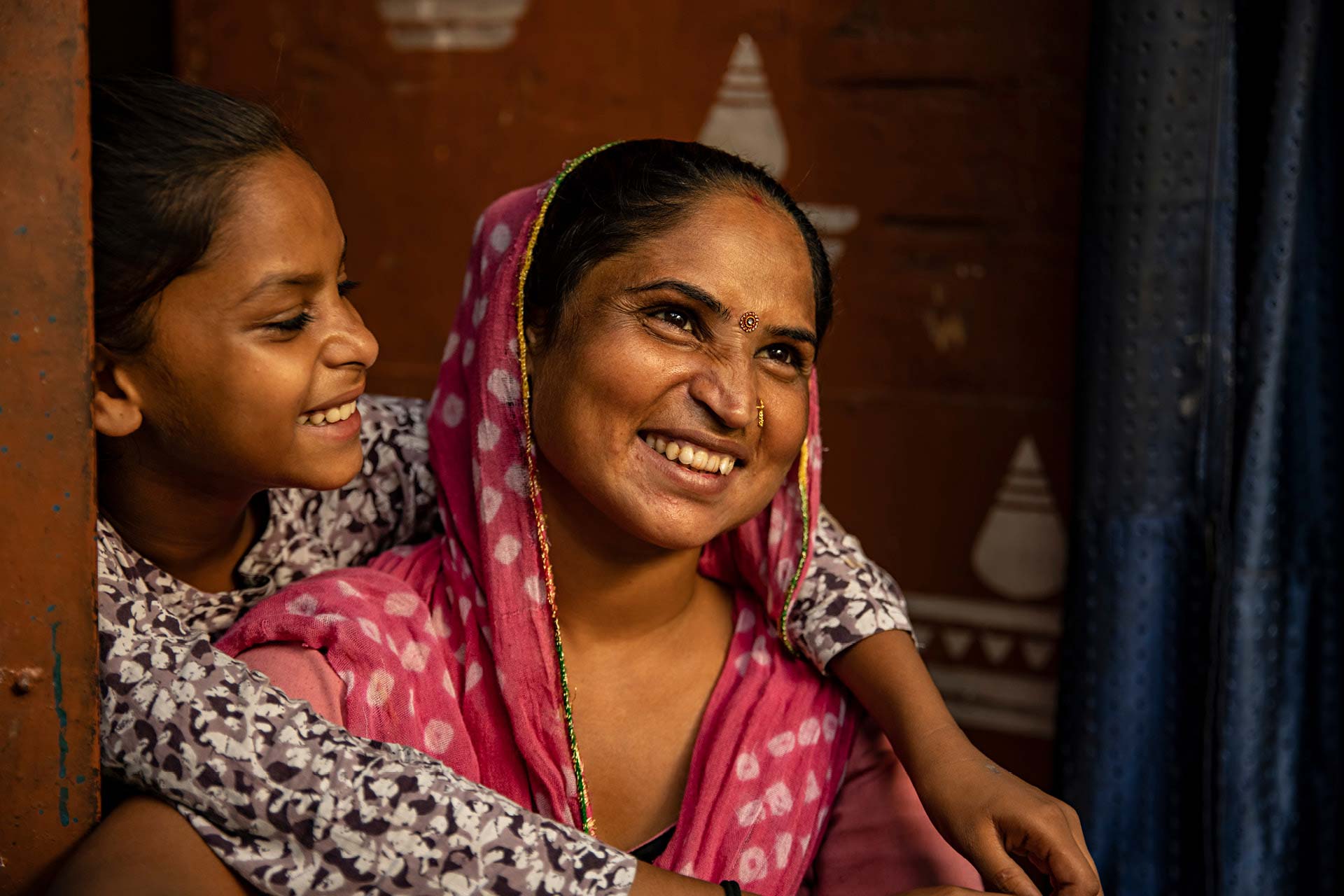 Image of a mother and daughter smiling embracing each other