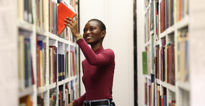 PhD students picking a book from the library