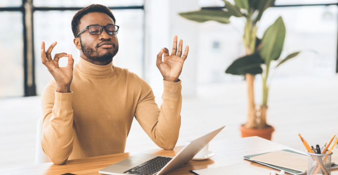 Relaxed employee meditates in work