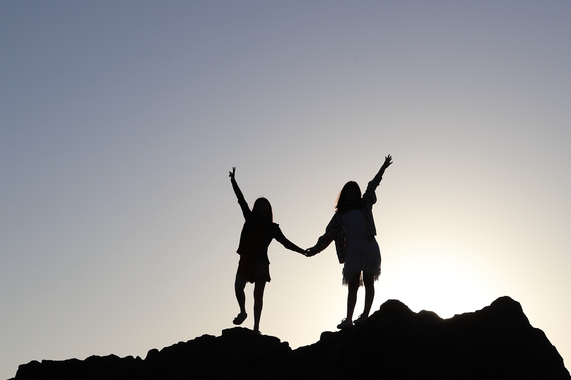 Two people holding hands on a hill