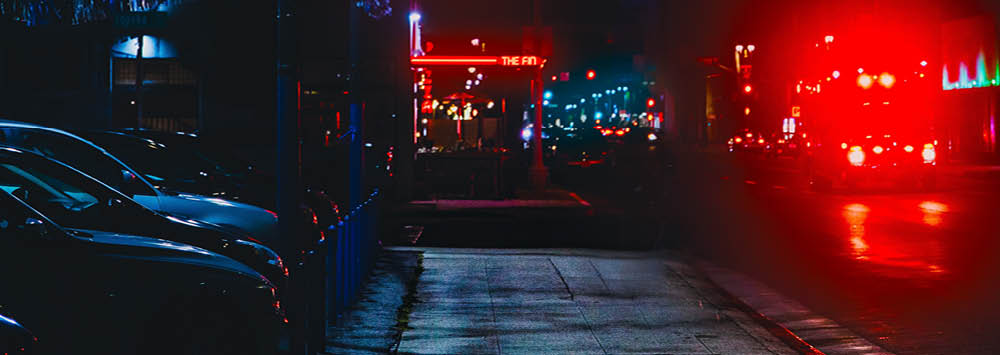 A strip of bars in the nighttime.