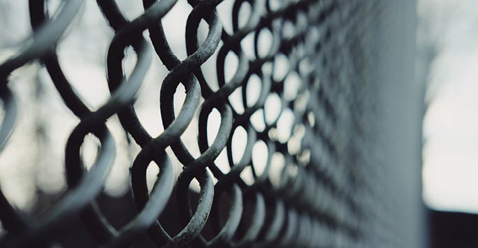 A metal chain fence in grey