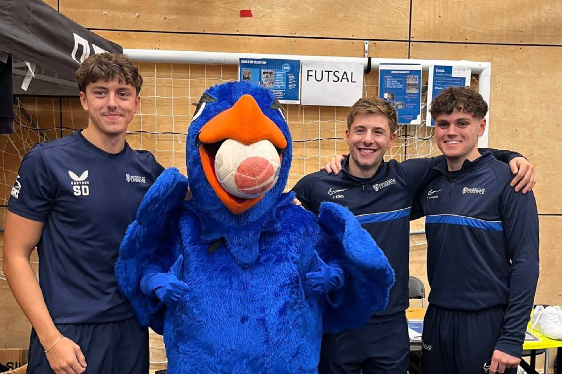 Liver bird mascot standing with members of a sports team