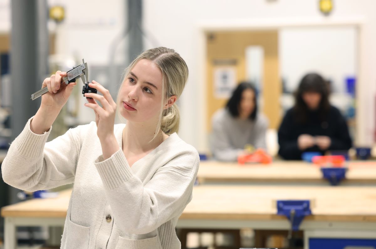 Mechanical engineering student using tools