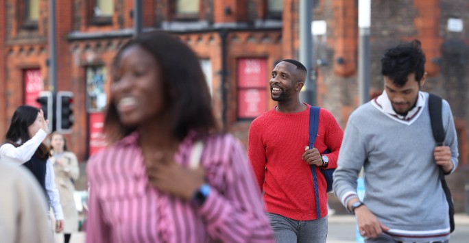 Students walking and smiling through University Square