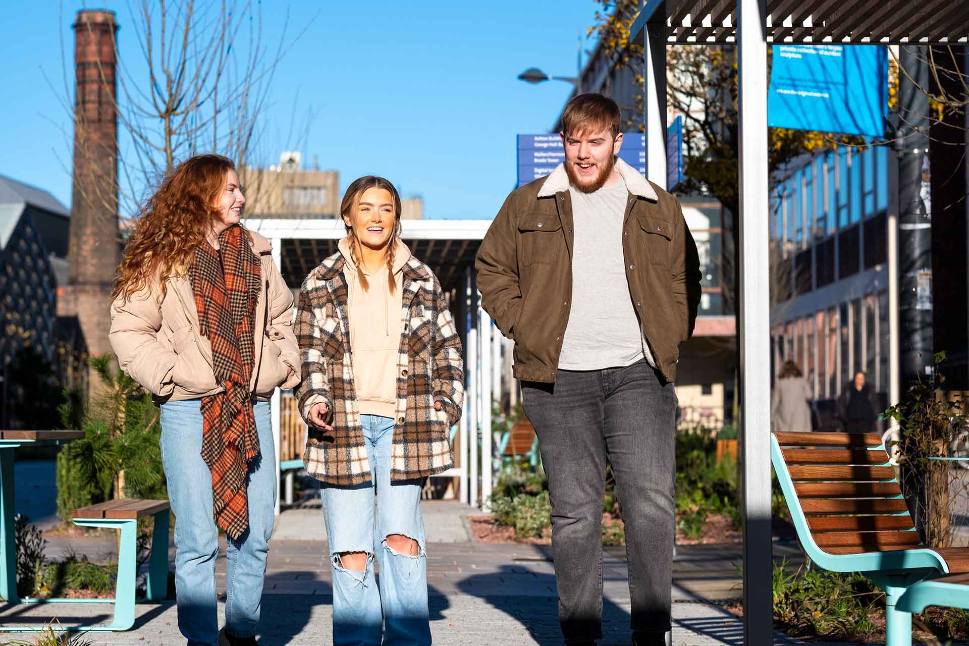 Three students walking on campus.