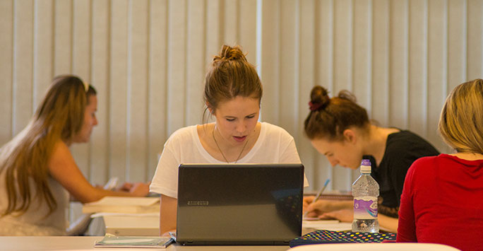 A student sat behind a desk working on her project.